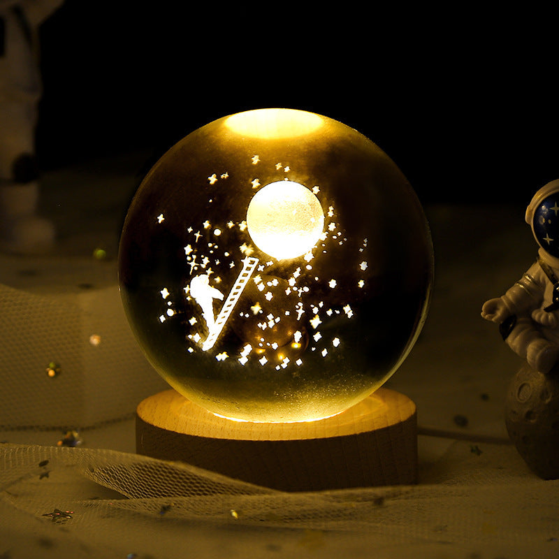 Glowing crystal ball with astronaut and moon design on a wooden base.