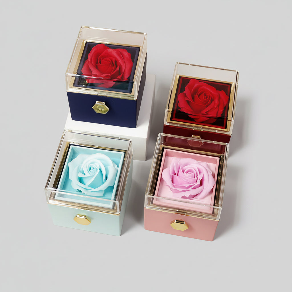 Four boxes with preserved roses inside, each in different colors, on a light pink background.