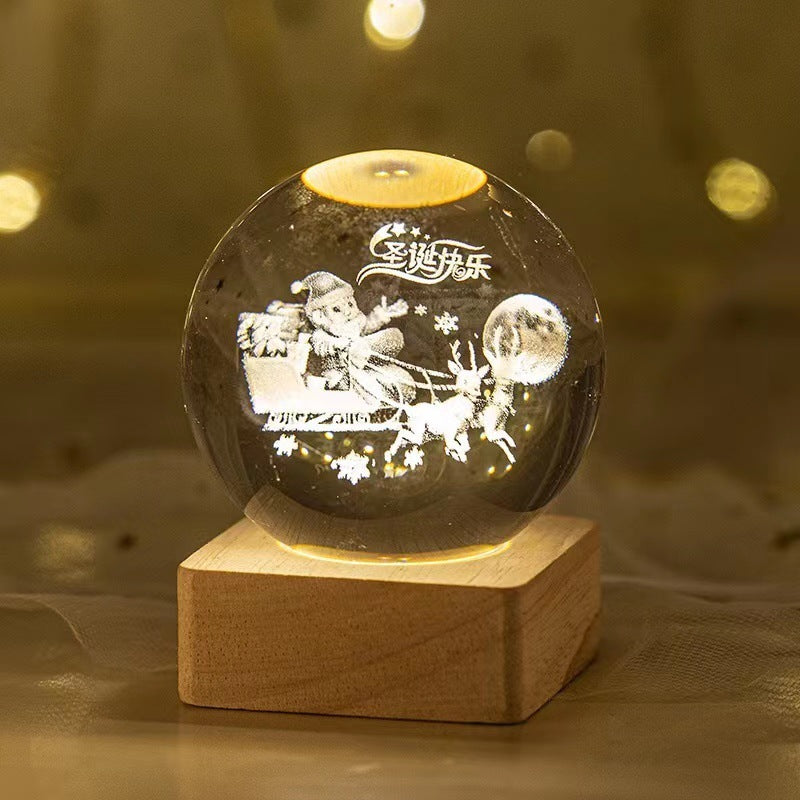 Decorative crystal ball with engraved design on a wooden base against a blurred background